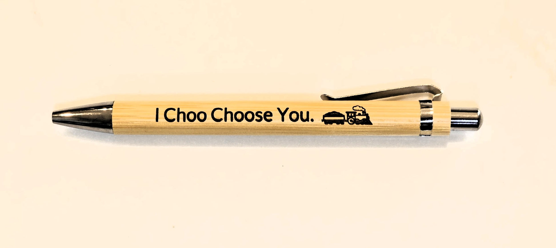 Wooden pen with 'I Choo Choose You' text on a beige background