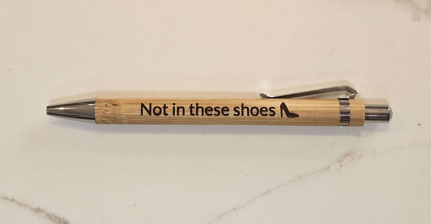 Wooden pen with 'Not in these shoes' engraving on a marble surface